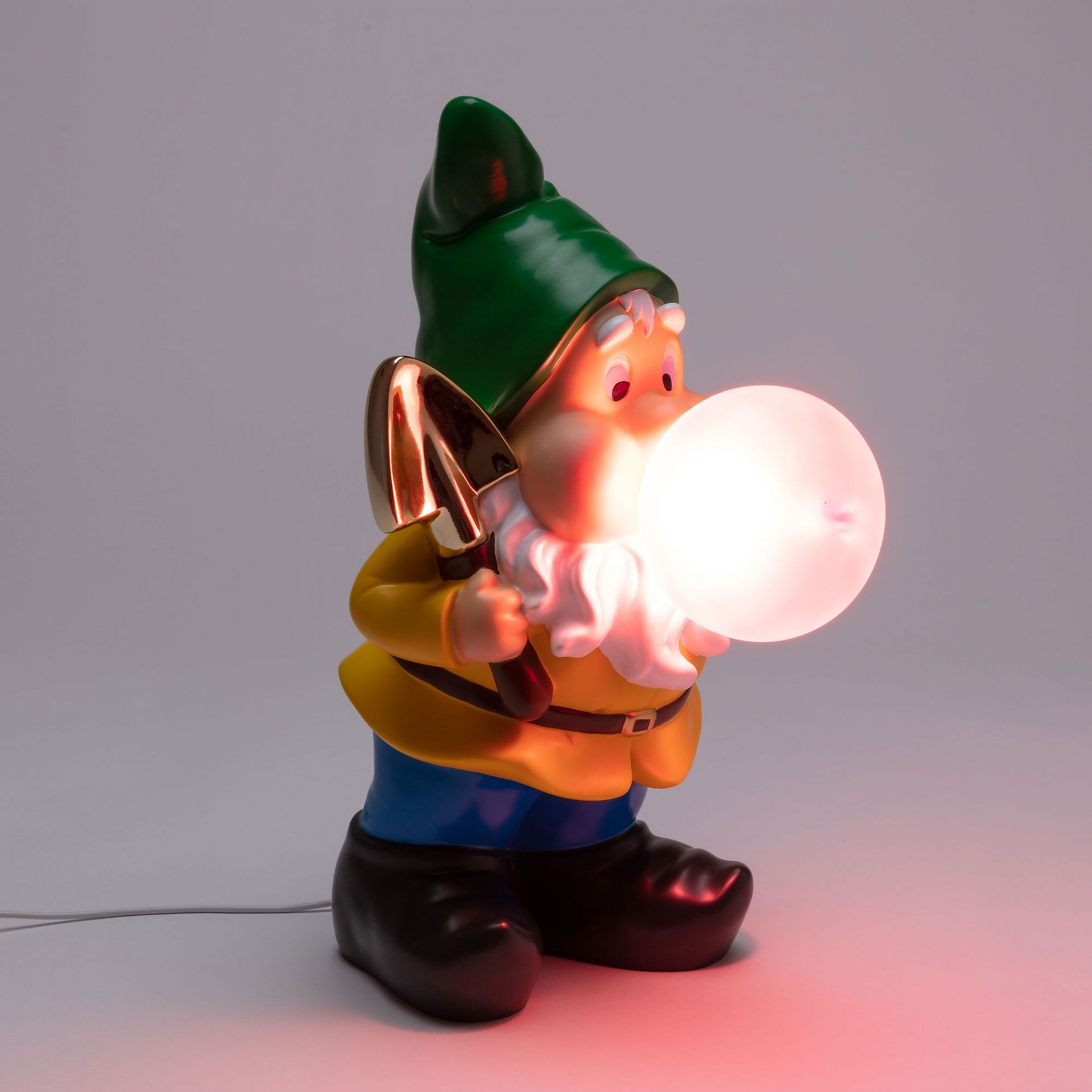 Seletti Gummy Working Leuchte: Gartenzwerg Lampe mit grüner Mütze, gelber Jacke und leuchtender Kugel.