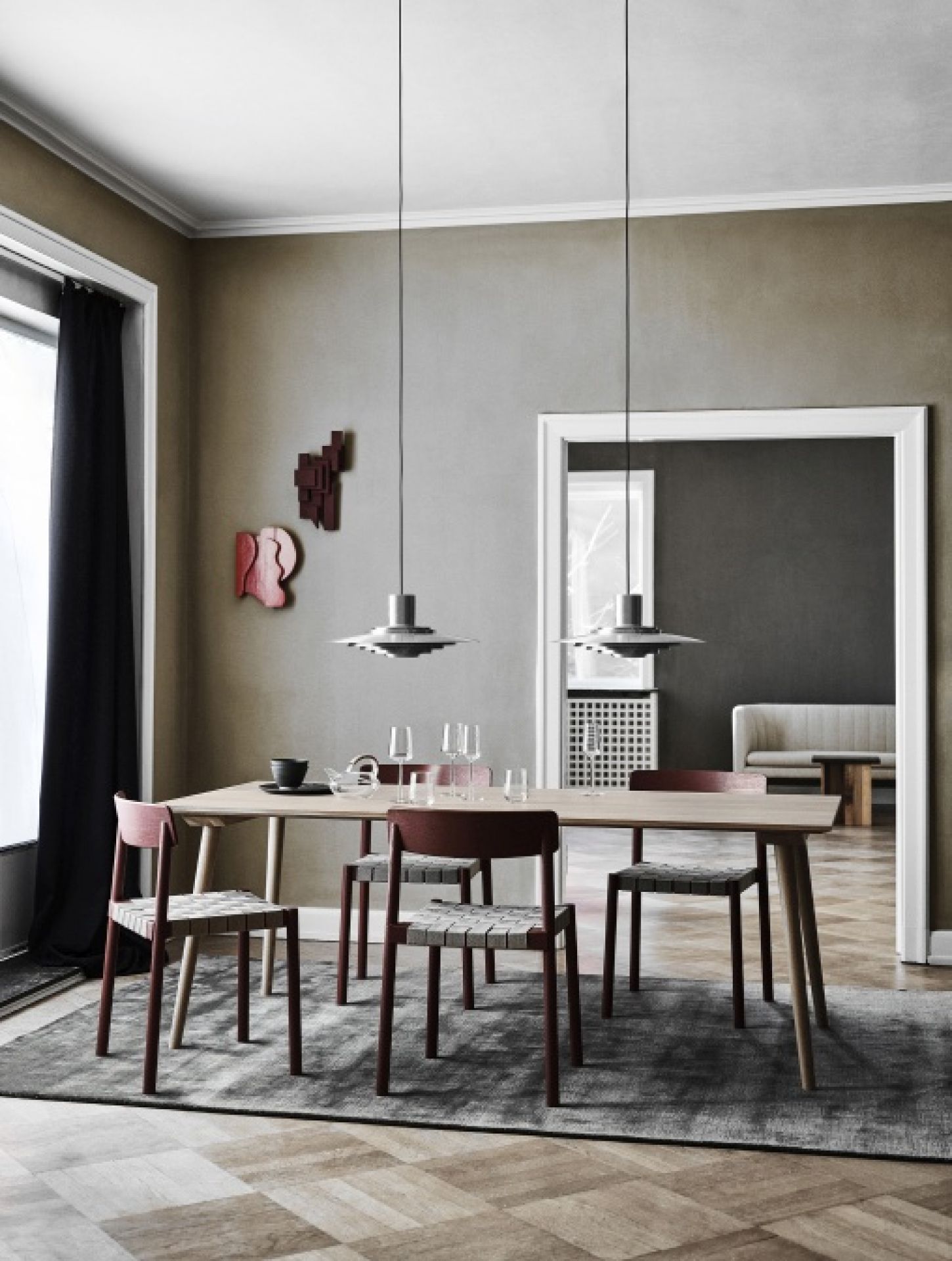 AndTradition In Between Table SK5 Esstisch mit Holzstühlen und Pendelleuchten in modernem Esszimmer.