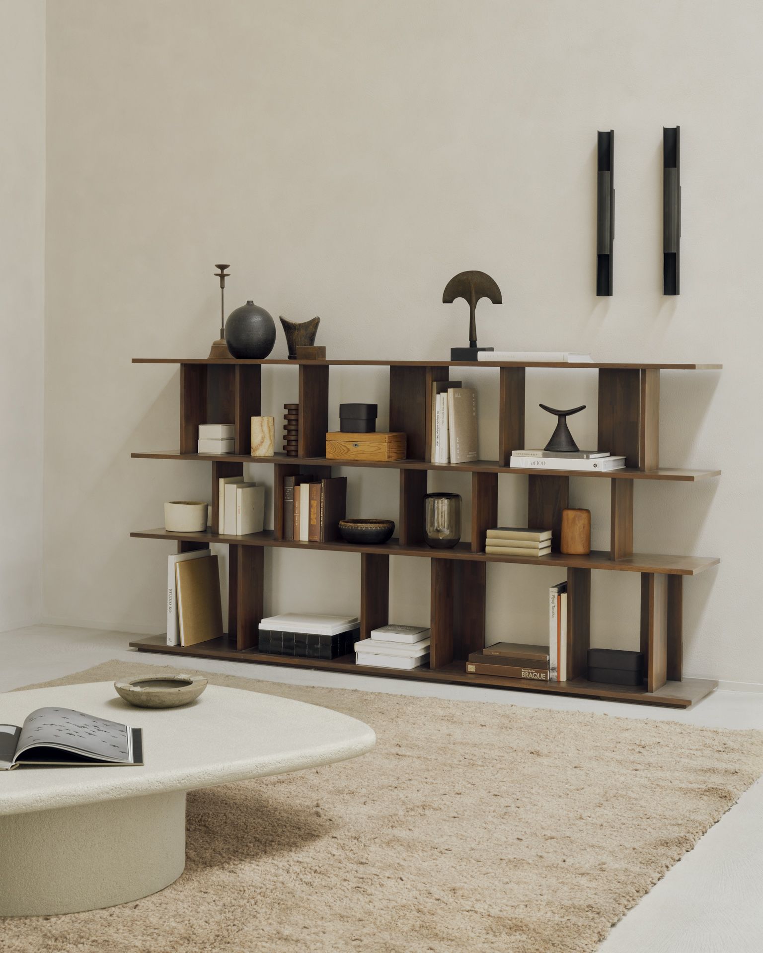 Ethnicraft Irregular Regal aus Teakholz in Dunkelbraun, modernes Bücherregal mit Wohnaccessoires im stilvollen Wohnzimmer.