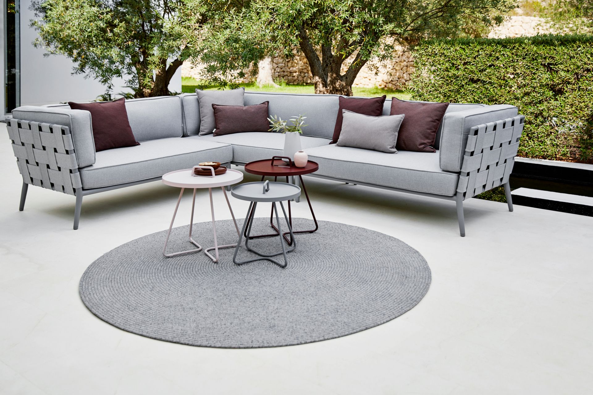 Cane-Line Conic AirTouch Modulsofa, hellgraues 2-Sitzer Outdoor Sofa mit Flechtmuster und Kissen im Garten.
