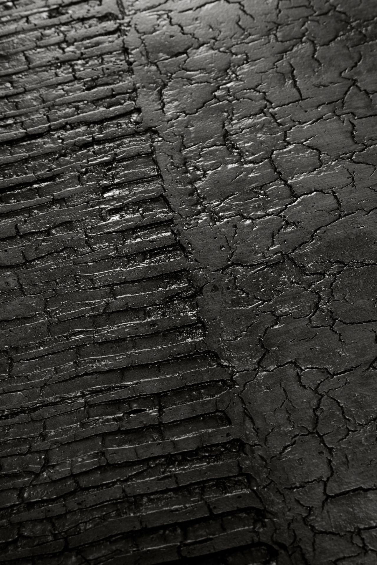 Detailaufnahme der schwarzen, rissigen Oberfläche des Luna Couchtischs im Lava Linear Design von Ethnicraft.