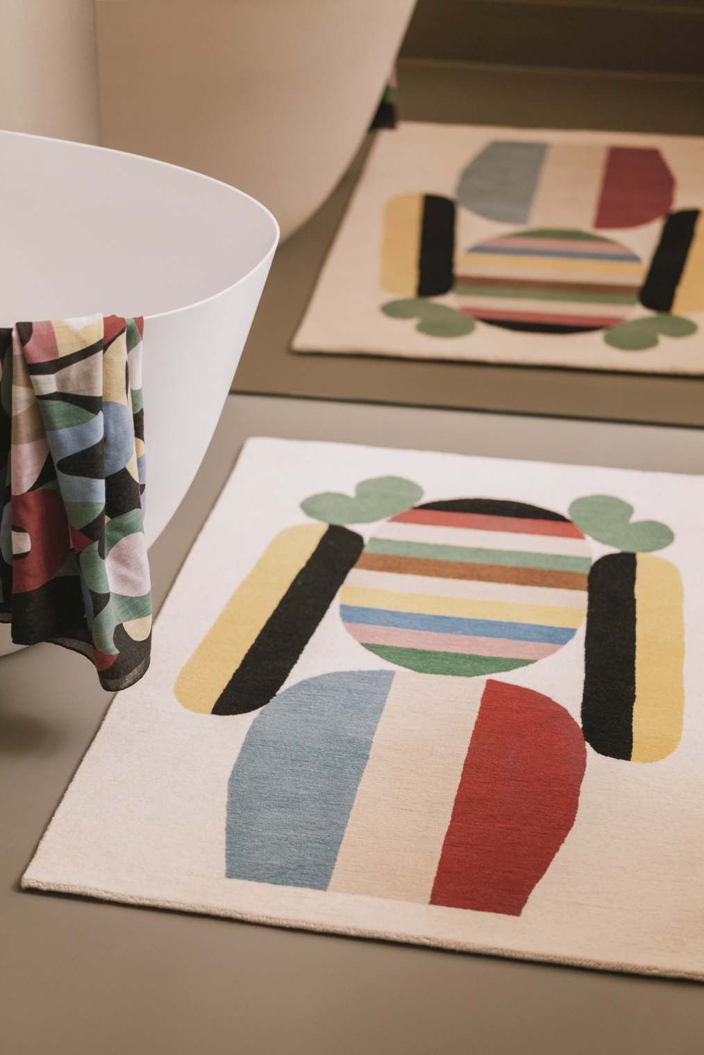 Elis Teppich von Designercarpets mit abstraktem, farbenfrohem Muster im Badezimmer neben einer Badewanne.
