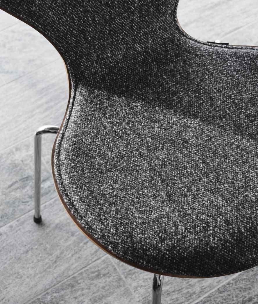 Detailaufnahme: Siebener Stuhl von Fritz Hansen, Jubiläumsmodell mit grau meliertem Stoffbezug. Designklassiker.