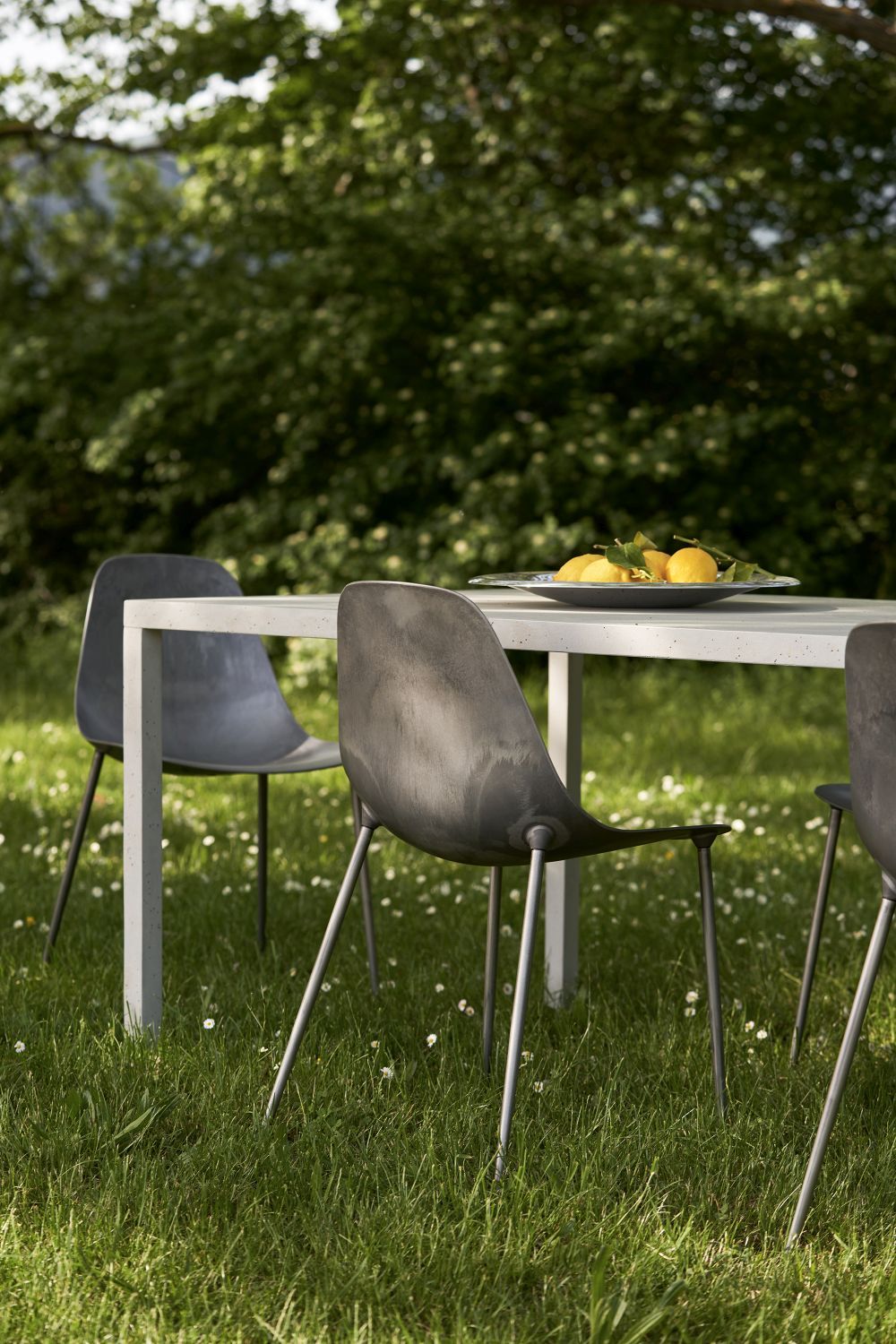 Mammamia Raw Stuhl von Opinion Ciatti, grauer Design Stuhl mit Metallbeinen im Garten.