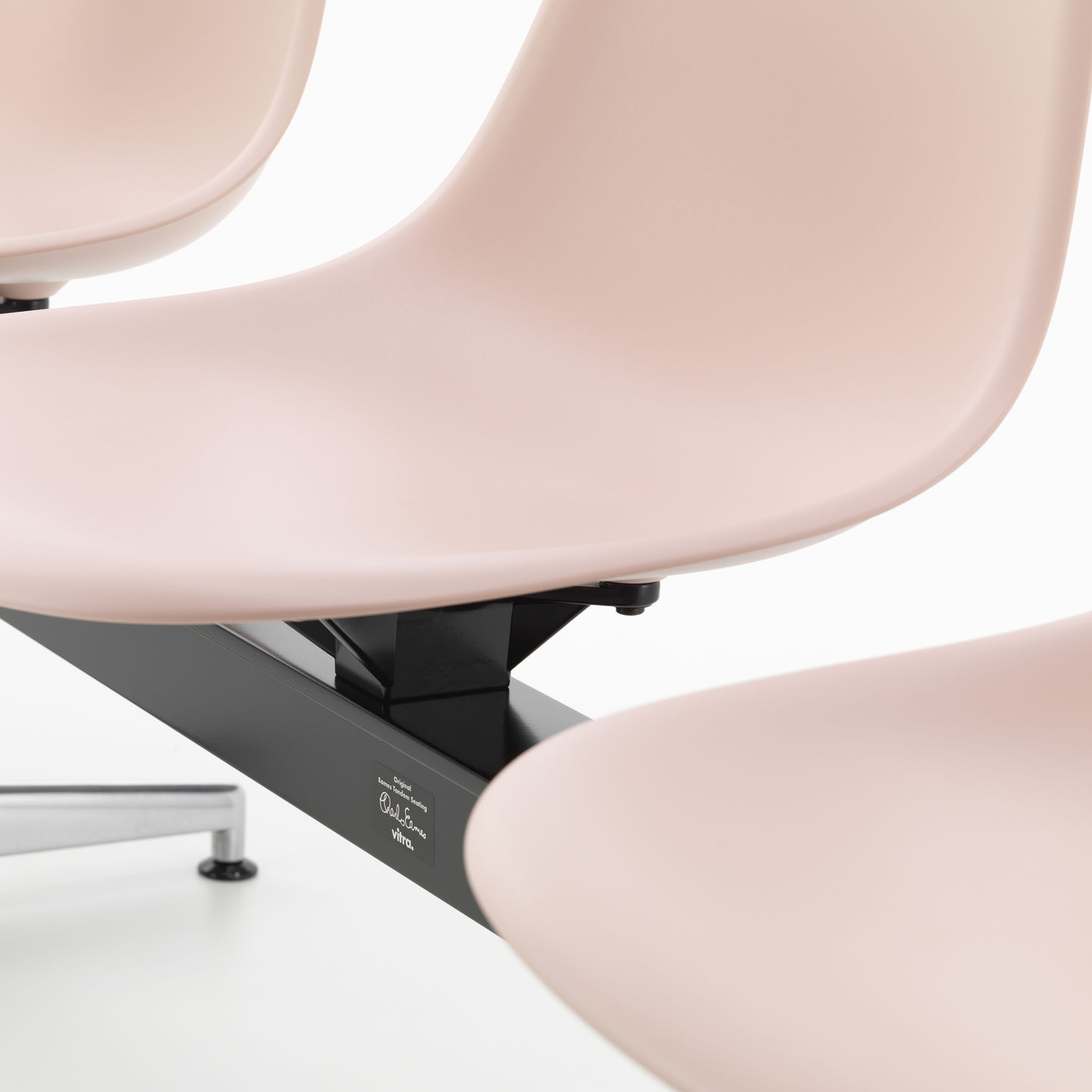 Detailaufnahme: Rosa Eames Plastic Side Chair auf Traverse von Vitra, modernes Design Sitzmöbel.