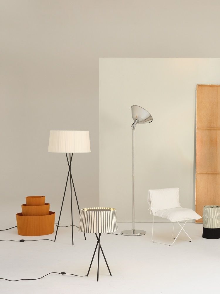 Tripode Tischleuchte von Santa & Cole mit gestreiftem Lampenschirm und schwarzem Stativfuß im minimalistischen Ambiente.