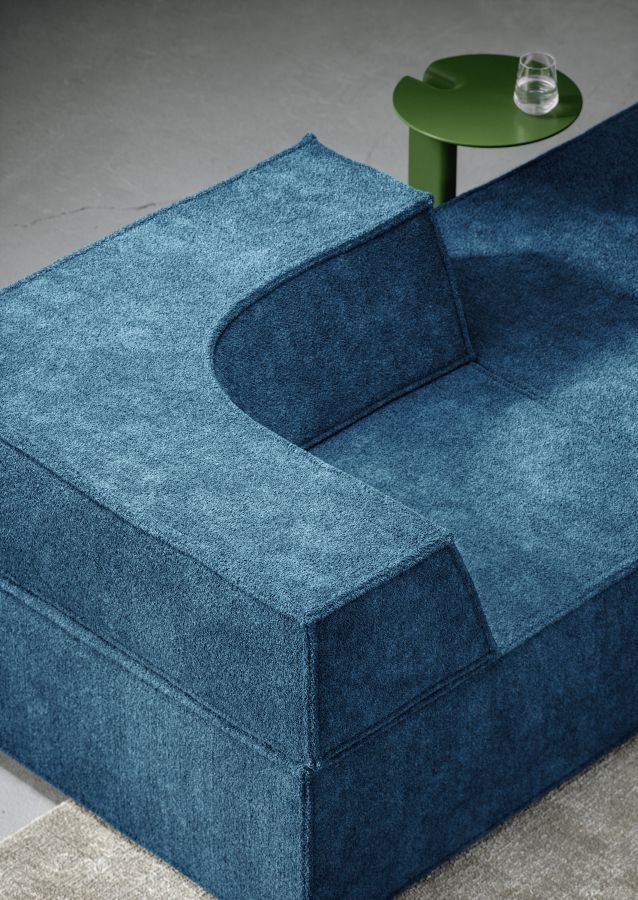 Detailaufnahme des blauen Trio Sofa Modulsofas von Cor mit grünen Beistelltisch und Wasserglas.