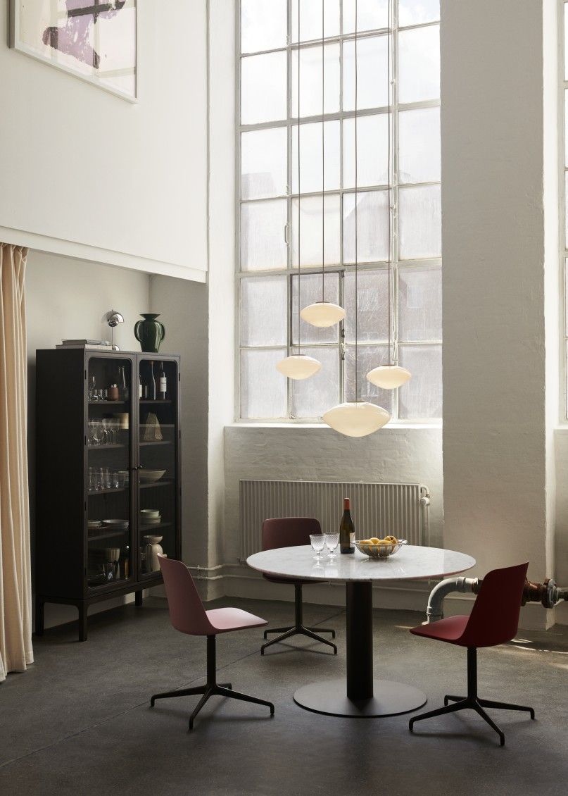 Esszimmer mit AndTradition Mist Pendelleuchten aus Opalglas über einem runden Tisch.