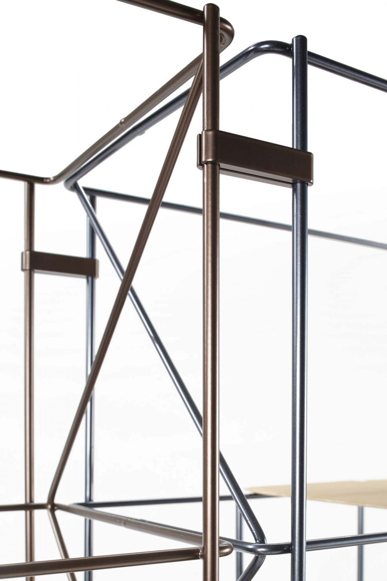 Detailaufnahme des Network Bücherregals von Casamania Horm, modernes Design mit Metallrahmen in Bronze und Schwarz.