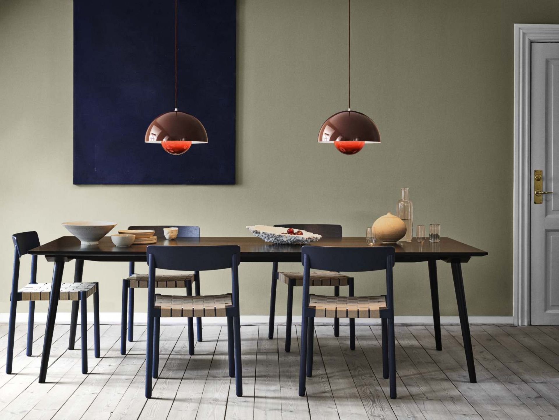 AndTradition In Between Table SK5 aus Holz mit Stühlen und Pendelleuchten im Esszimmer.