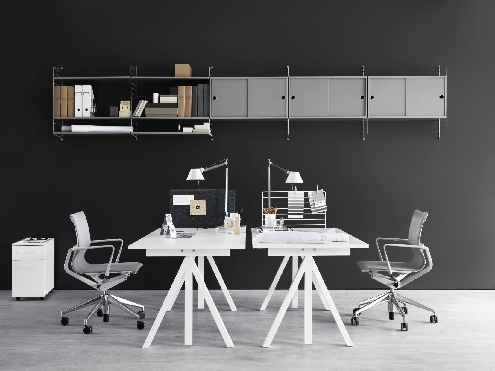 Funktionale Büroeinrichtung: Zwei Works Schreibtische Fix B140cm von String Furniture mit Regalsystem und Bürostühlen.