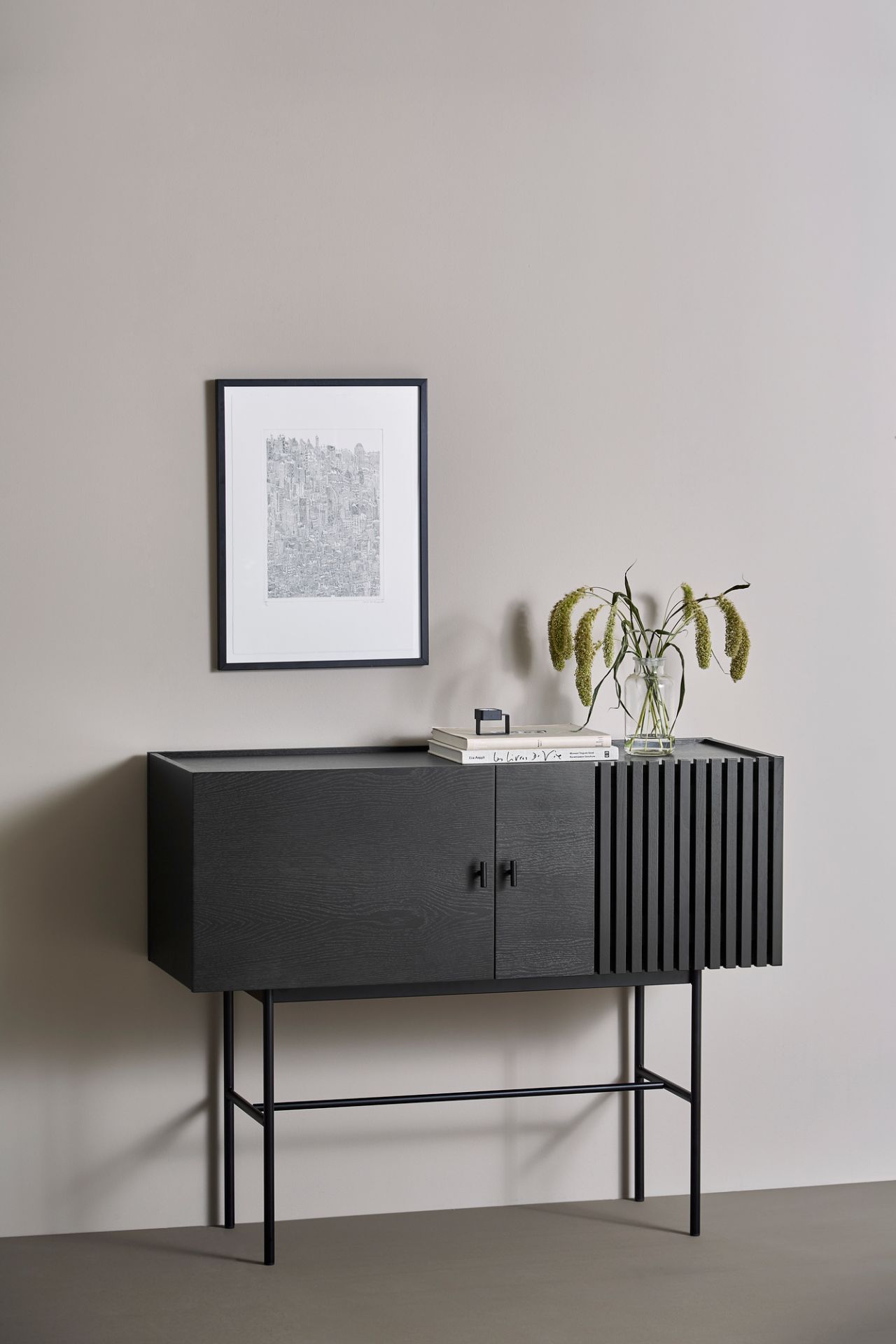 Schwarzes Array Sideboard von Woud (120cm) mit Türen und Lamellen, auf schlanken Beinen.