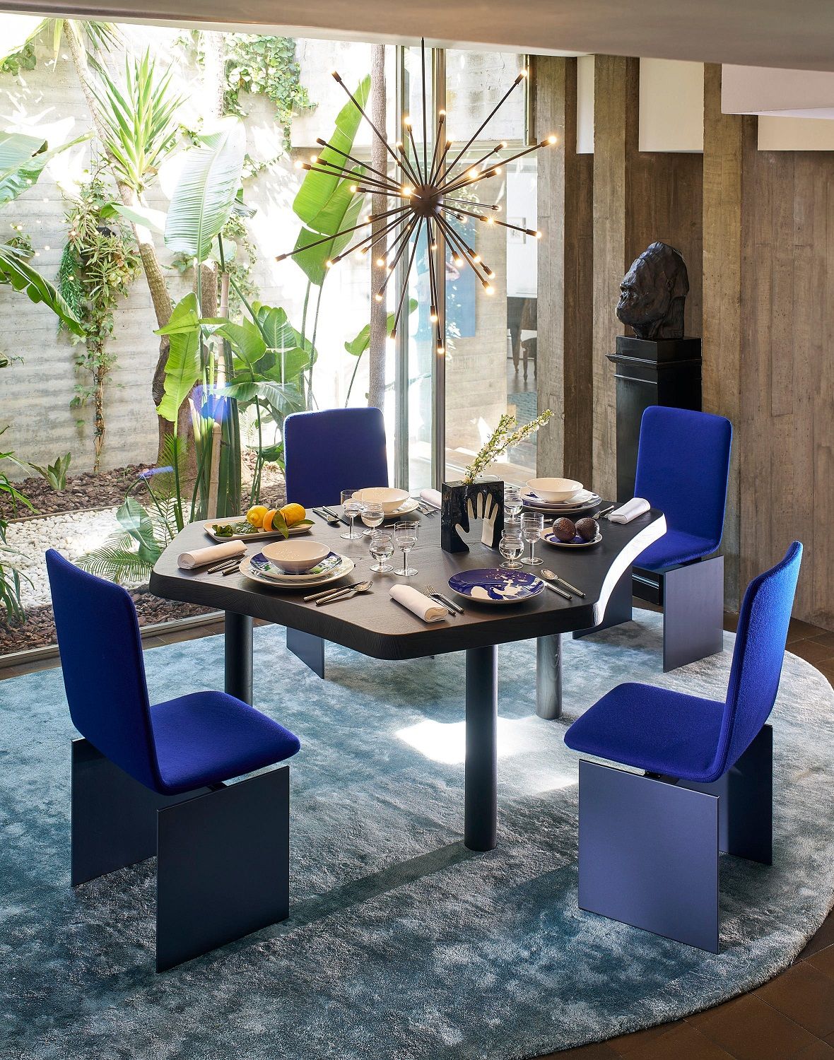 Esszimmer mit Cassina Galaxy Hängeleuchte, Esstisch und blauen Stühlen. Moderne Innenarchitektur.