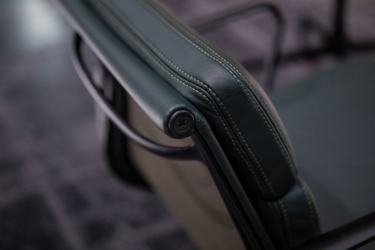 Detailaufnahme des grünen Vitra EA 207 Soft Pad Sessel Armlehne mit feinen Ziernähten.