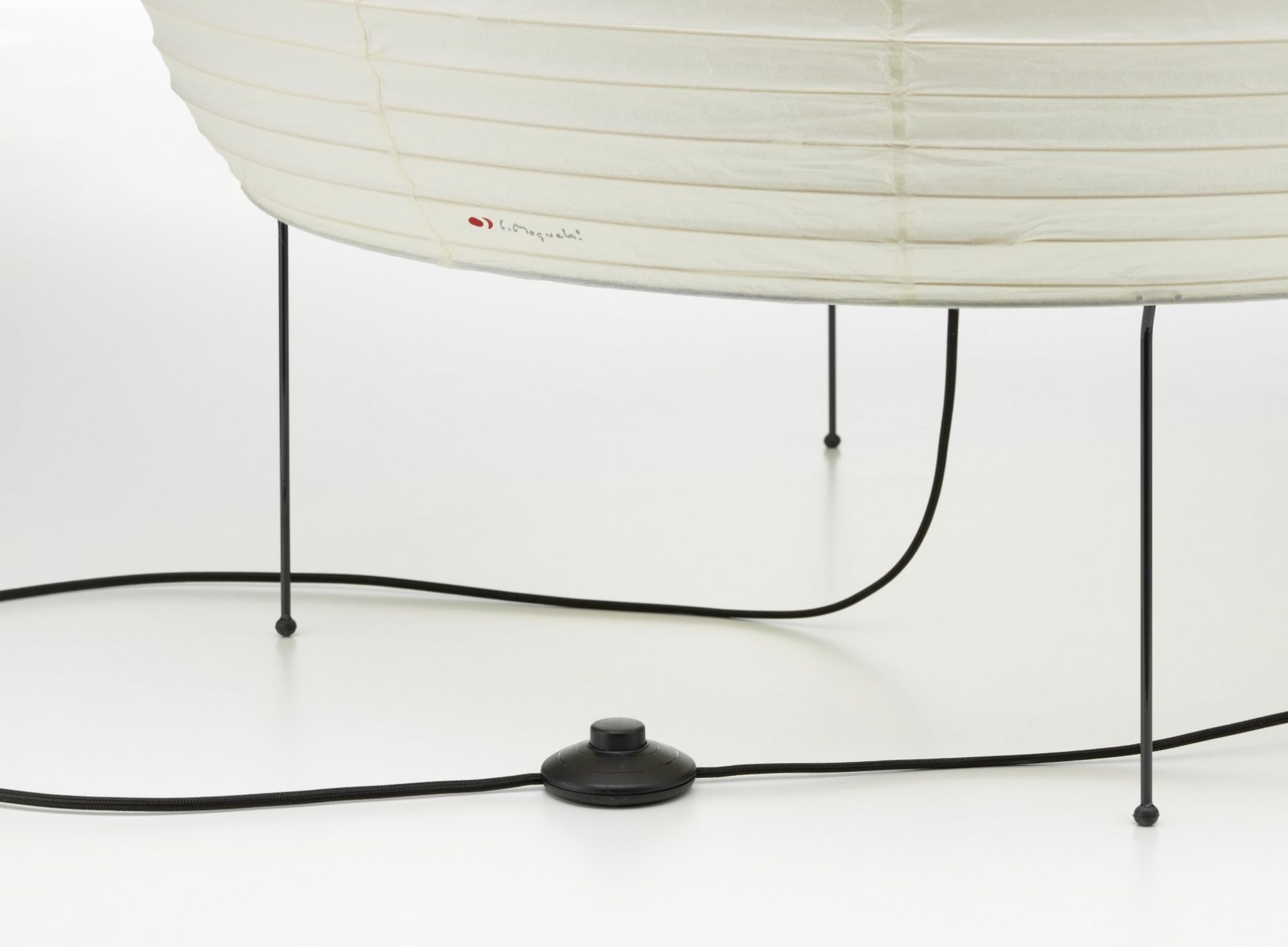 Detailaufnahme der Akari 25N Stehleuchte von Vitra, mit Papierschirm, schwarzem Kabel und Fußschalter.