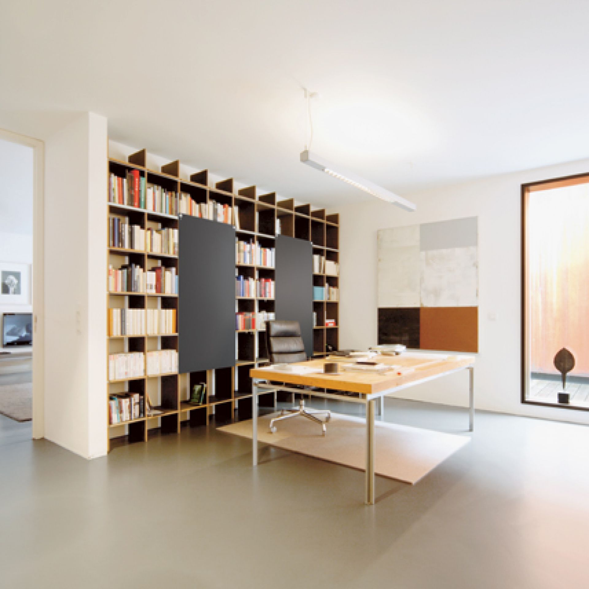 FNP Regal von Nils Holger Moormann im modernen Arbeitszimmer mit Schreibtisch und Bücherregal.