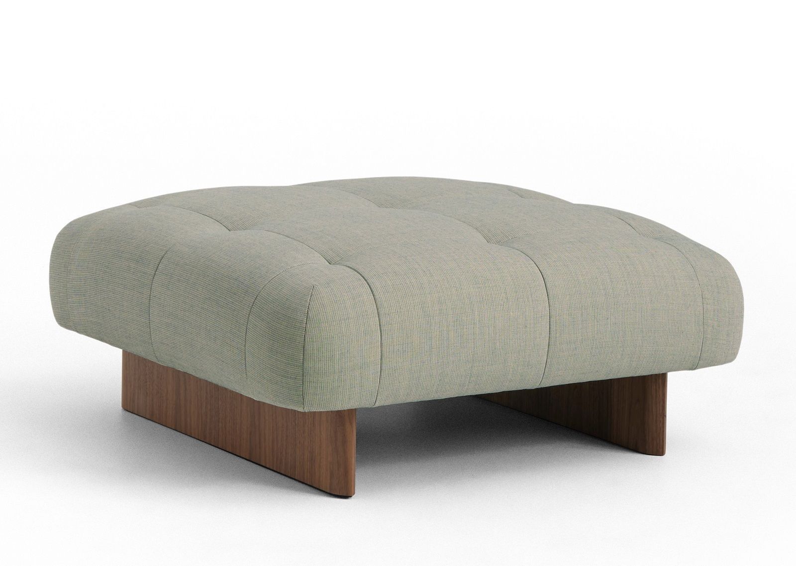 Quilton Ottoman Hocker von Hay, gepolstert mit hellgrauem Stoff und Holzfuß, freistehend auf weißem Hintergrund.