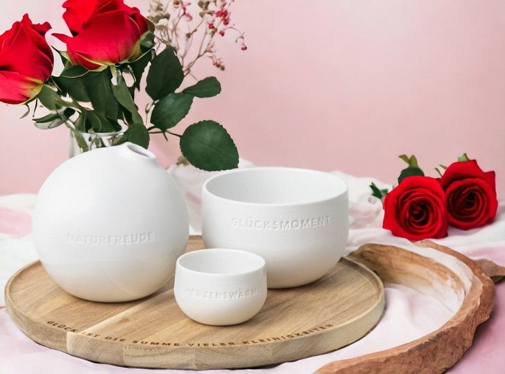 Räder Tablett der kleinen Dinge mit Porzellan-Vasen und Schalen, dekorativ mit Rosen auf rosa Hintergrund.