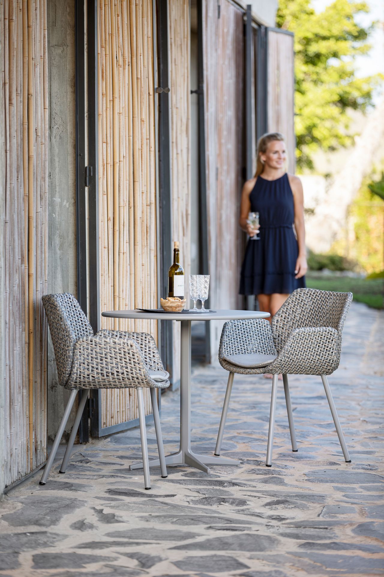 Vibe Outdoor Sessel von Cane-Line aus Rattan mit Tisch und Dekoration im Garten.