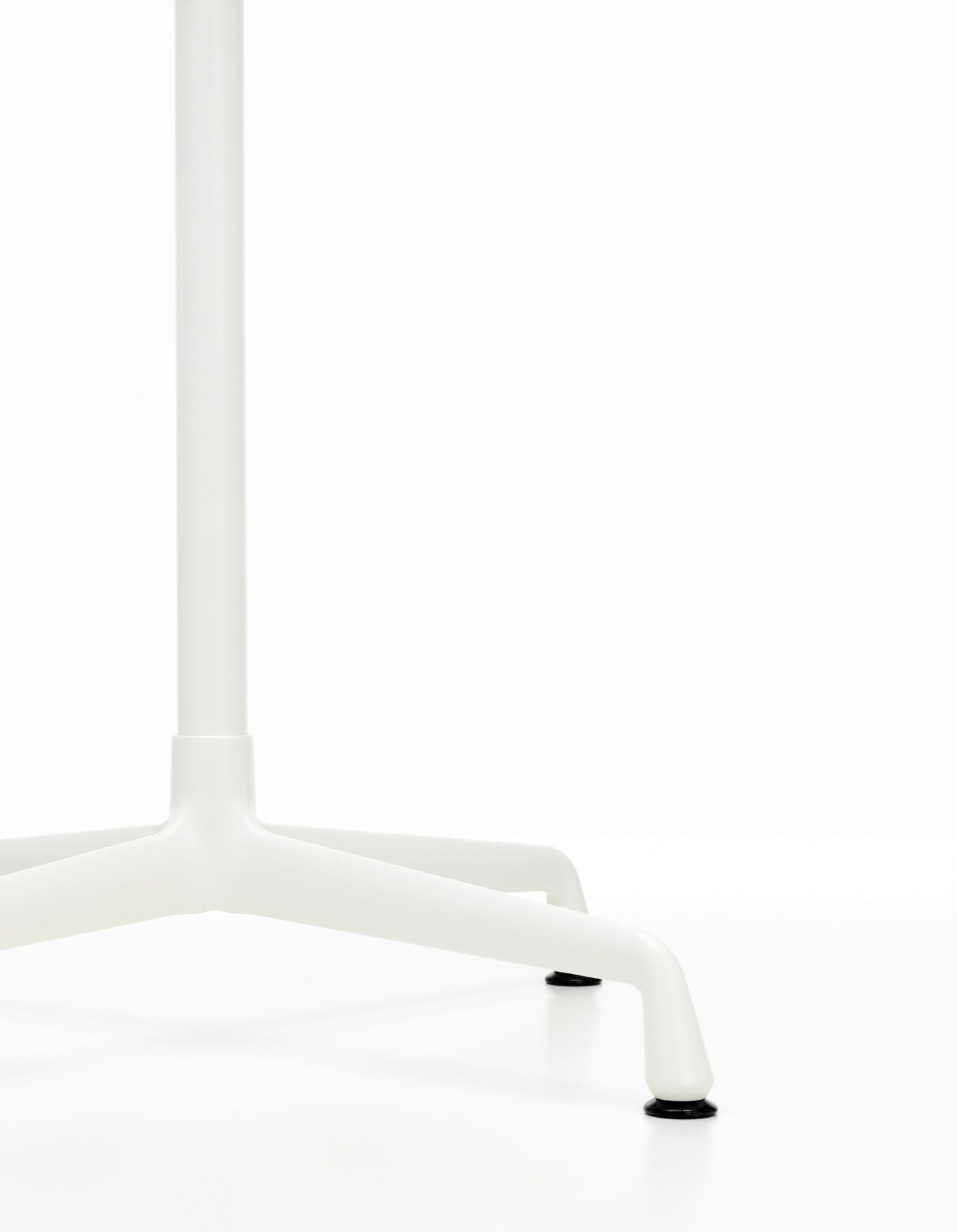 Detailaufnahme des weißen Eames Contract Table Tischfußes von Vitra mit vier Beinen und schwarzem Bodenschutz.