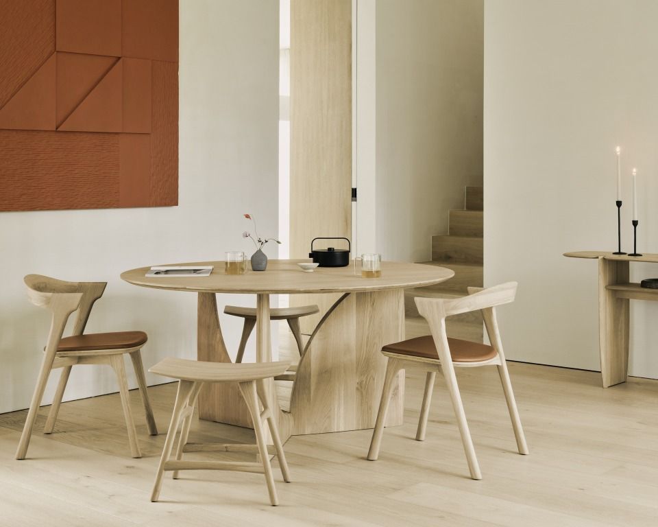 Ethnicraft Esstisch und Stühle aus Eiche in hellem, modernem Esszimmer mit minimalistischer Dekoration.