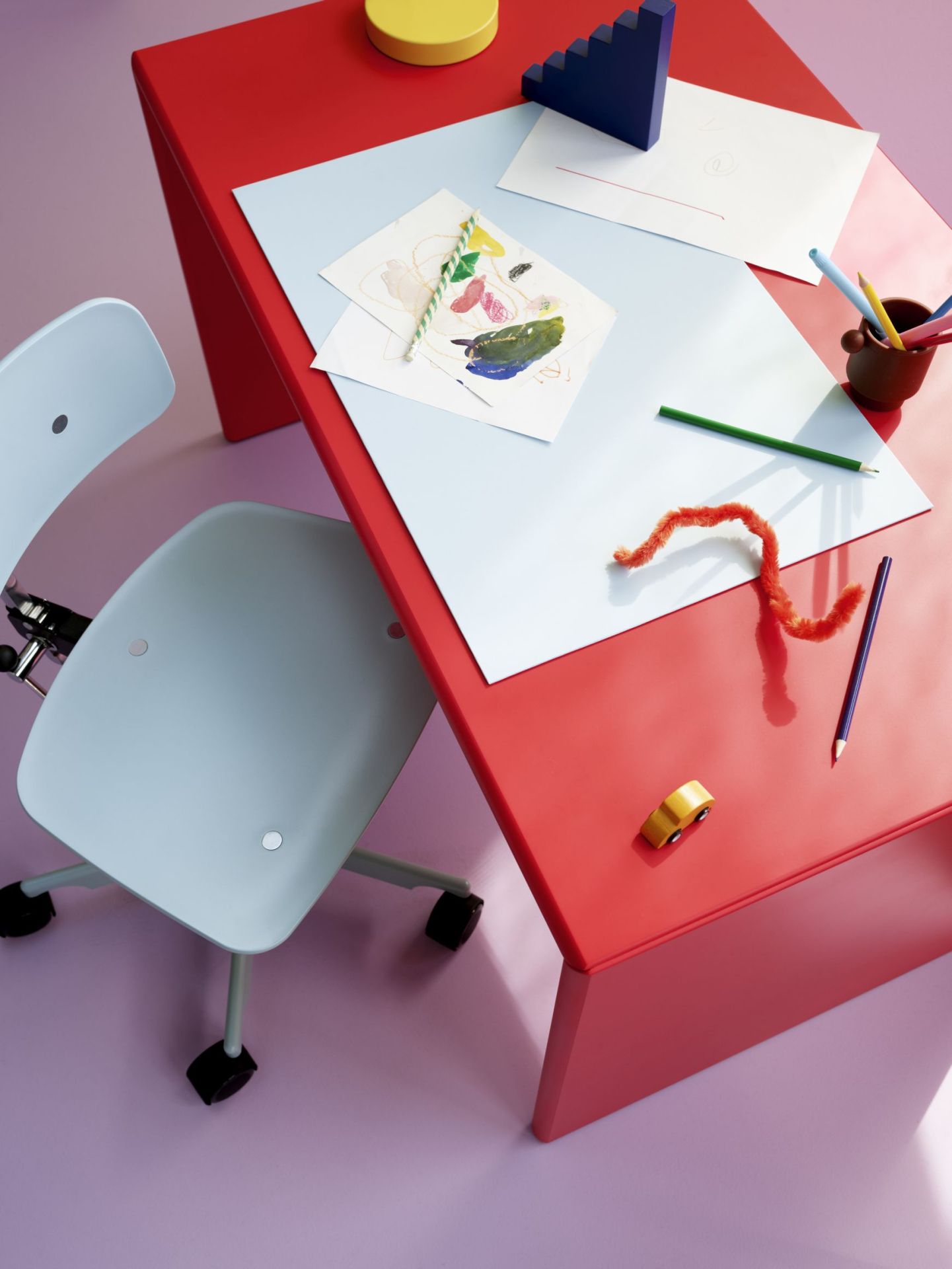 Kevi Kids Drehstuhl in Hellblau am roten Kinderschreibtisch mit Malutensilien und Spielzeug.