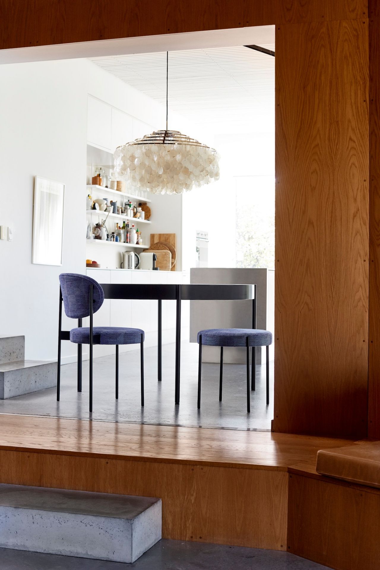 Innenaufnahme mit Verpan FUN Pendelleuchte, Muscheln, Messing, über Esstisch und Stühlen. Designlampe für Wohnraumbeleuchtung.