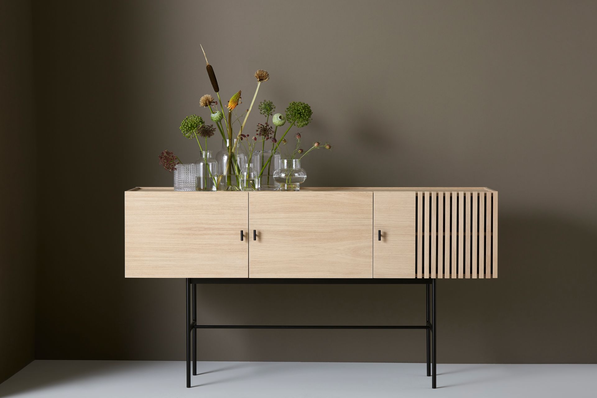Array Sideboard von Woud: Modernes Sideboard aus hellem Holz mit schwarzem Metallgestell.