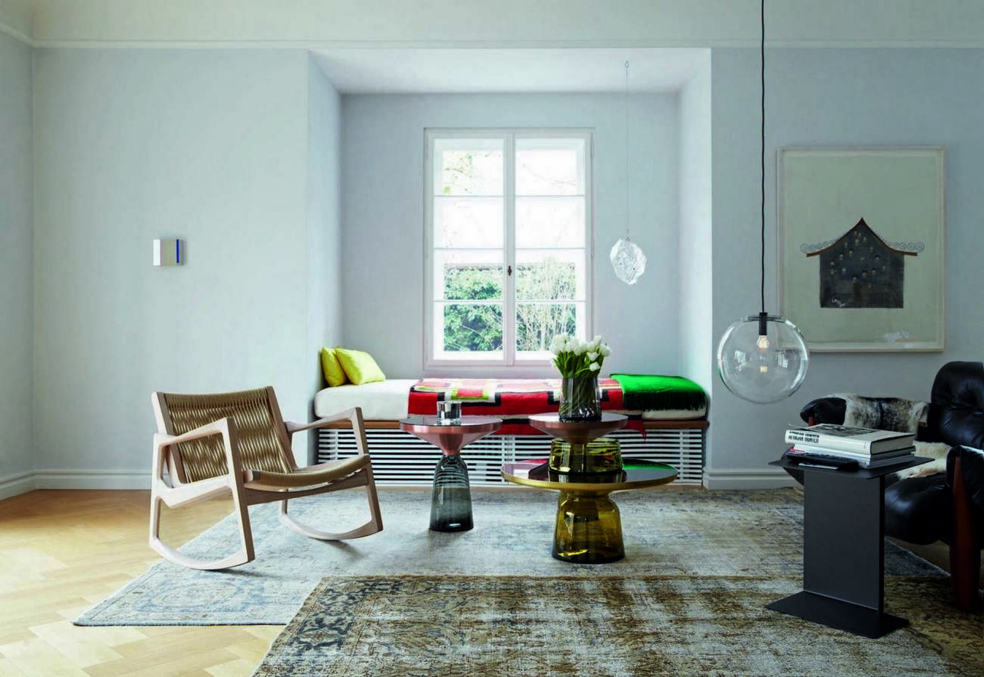 Heller Wohnraum mit ClassiCon Euvira Schaukelstuhl aus hellem Holz und geflochtener Sitzfläche, modernes Möbeldesign.