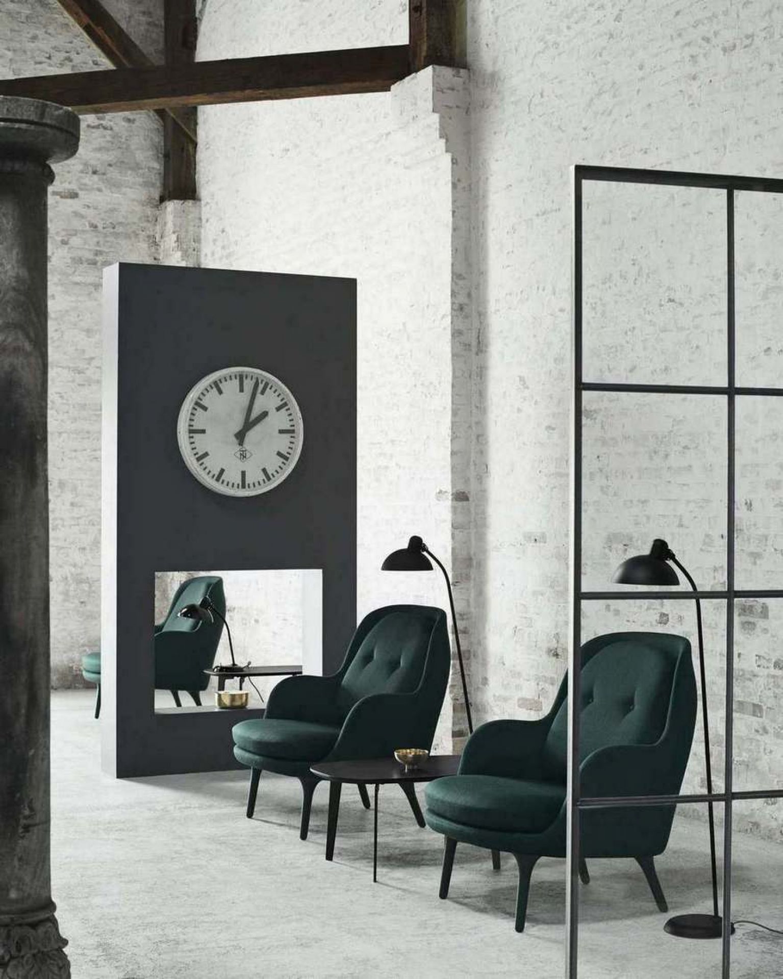Zwei grüne Fri Sessel von Fritz Hansen mit kleinem Tisch und Stehlampen in Loft-Atmosphäre.