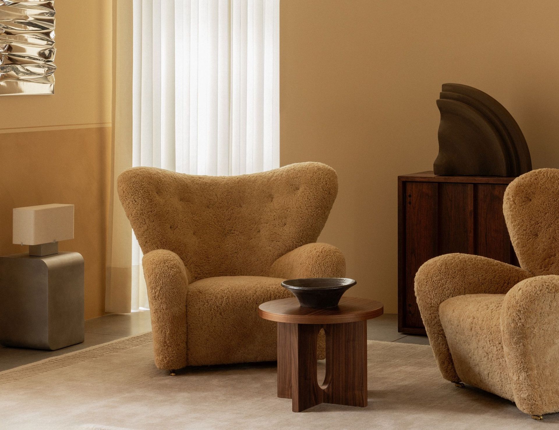 Audo Copenhagen Volume Side Table aus Holz neben Sessel und Dekoration in warmen Farben.