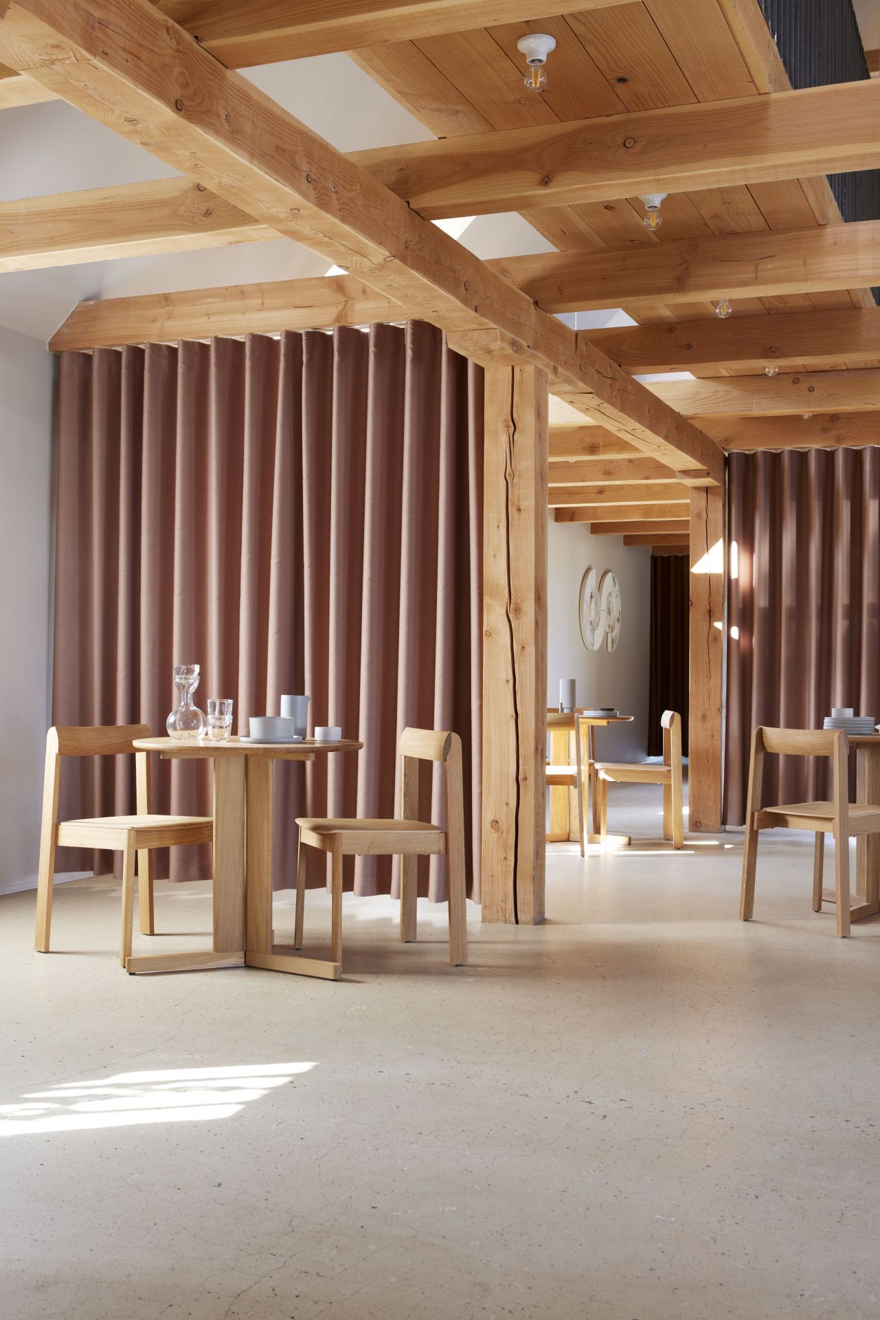 Trefoil Tisch von Form & Refine aus Eiche mit Stühlen in einem hellen Raum.