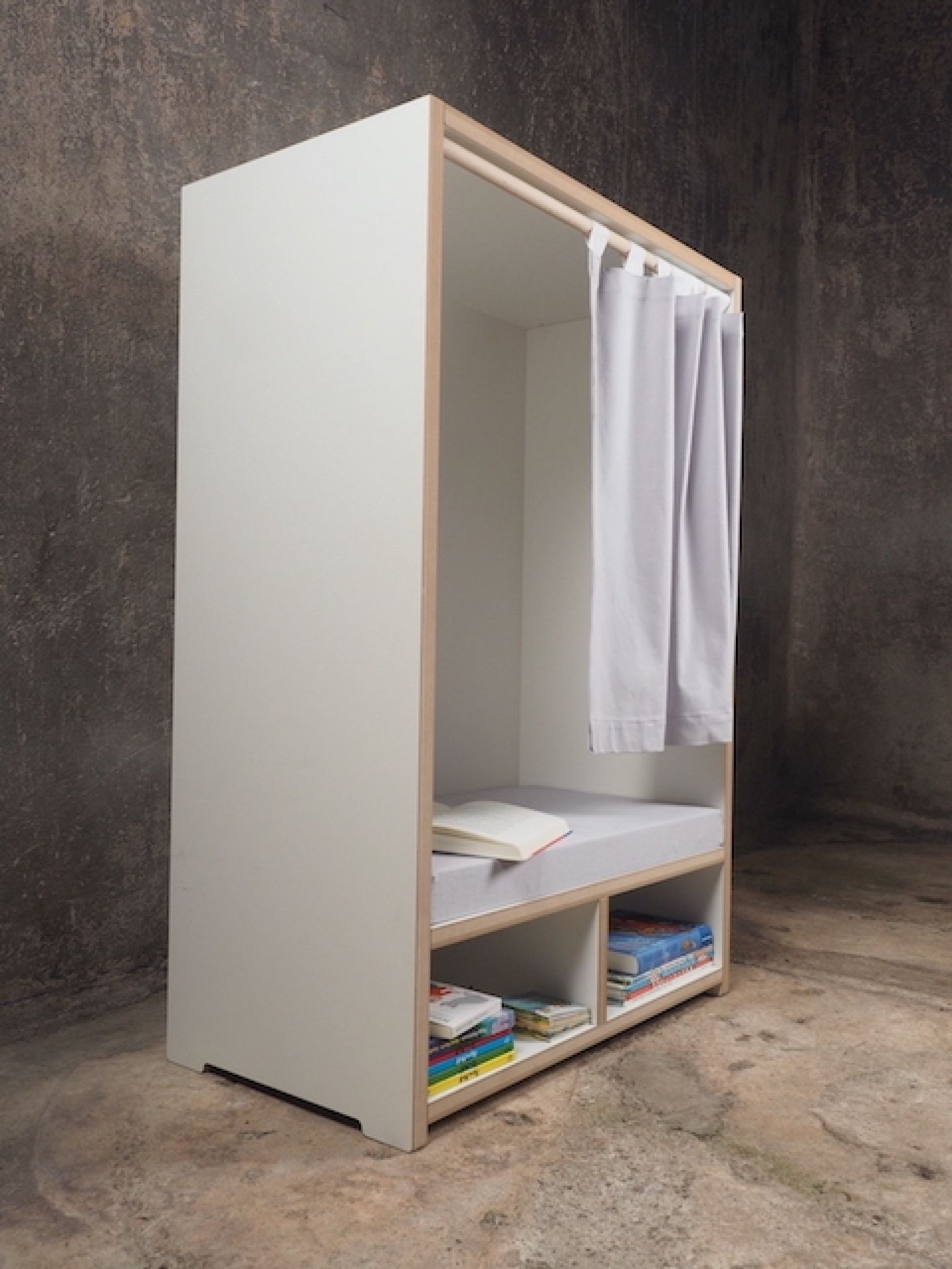 Tojo Kids Nische Lesebox: Weißes Kindermöbel mit Vorhang, Regalen und gemütlicher Leseecke mit Kissen.