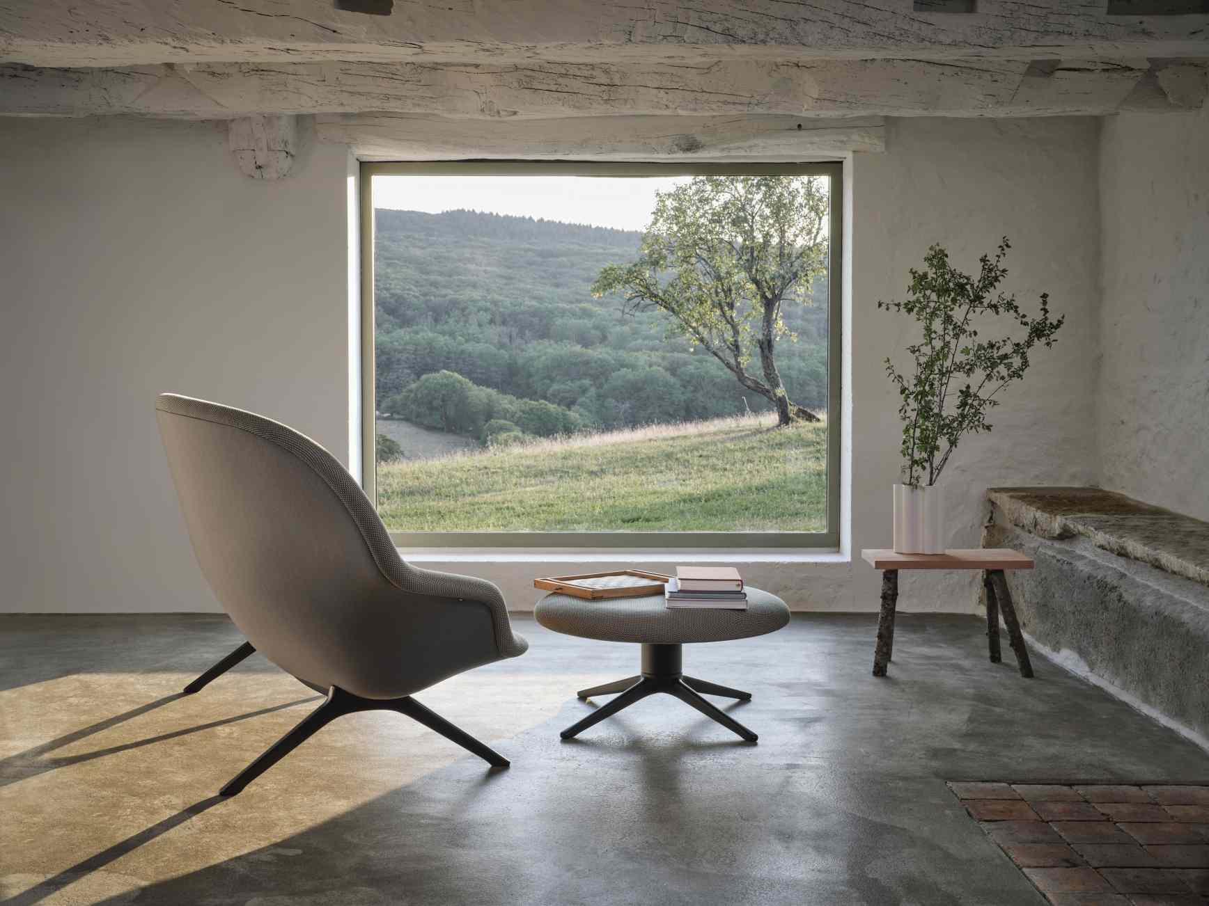 Graues Abalon Sofa von Vitra mit passendem Hocker in modernem Wohnzimmer mit Blick in die Natur.