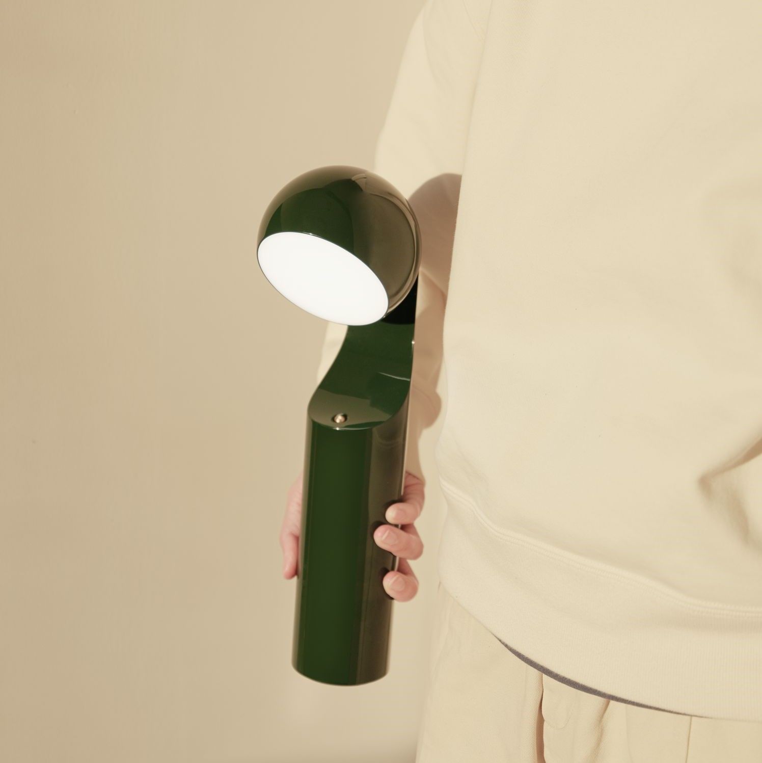 Grüne Mono Portable Akkuleuchte von house of home in der Hand gehalten. Tischleuchte, Leselampe.
