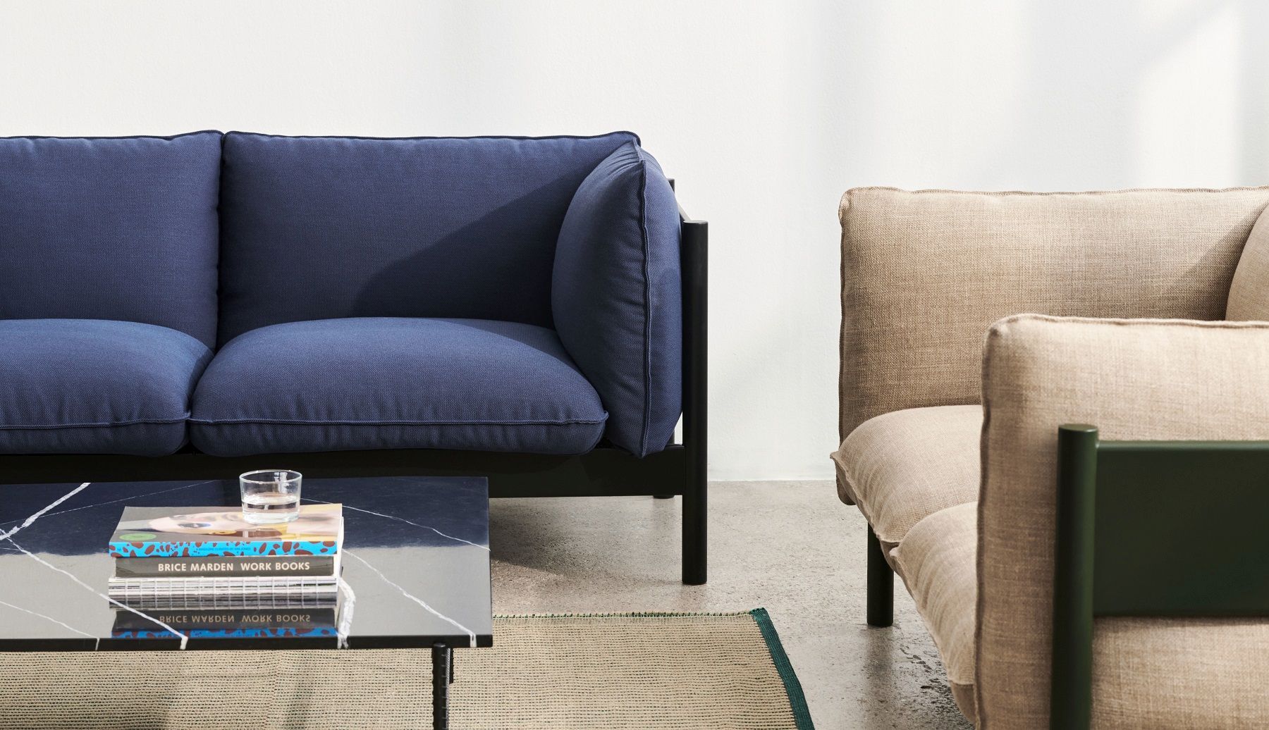 Nahaufnahme des Hay Arbour Eco Sofa 2-Sitzer in Blau, mit Couchtisch und beigem Sessel.