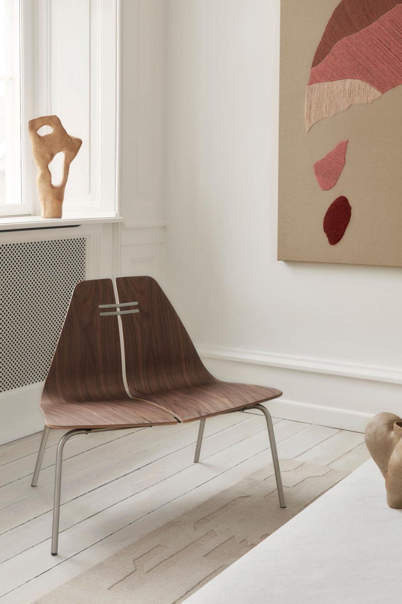 PK23 Loungesessel von Fritz Hansen aus Walnussholz mit Stahlgestell in modernem Wohnraum.