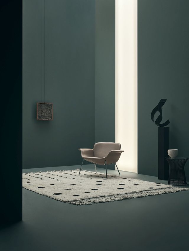 KN04 Stuhl von Knoll International, beiger Sessel mit Armlehnen auf einem gemusterten Teppich.