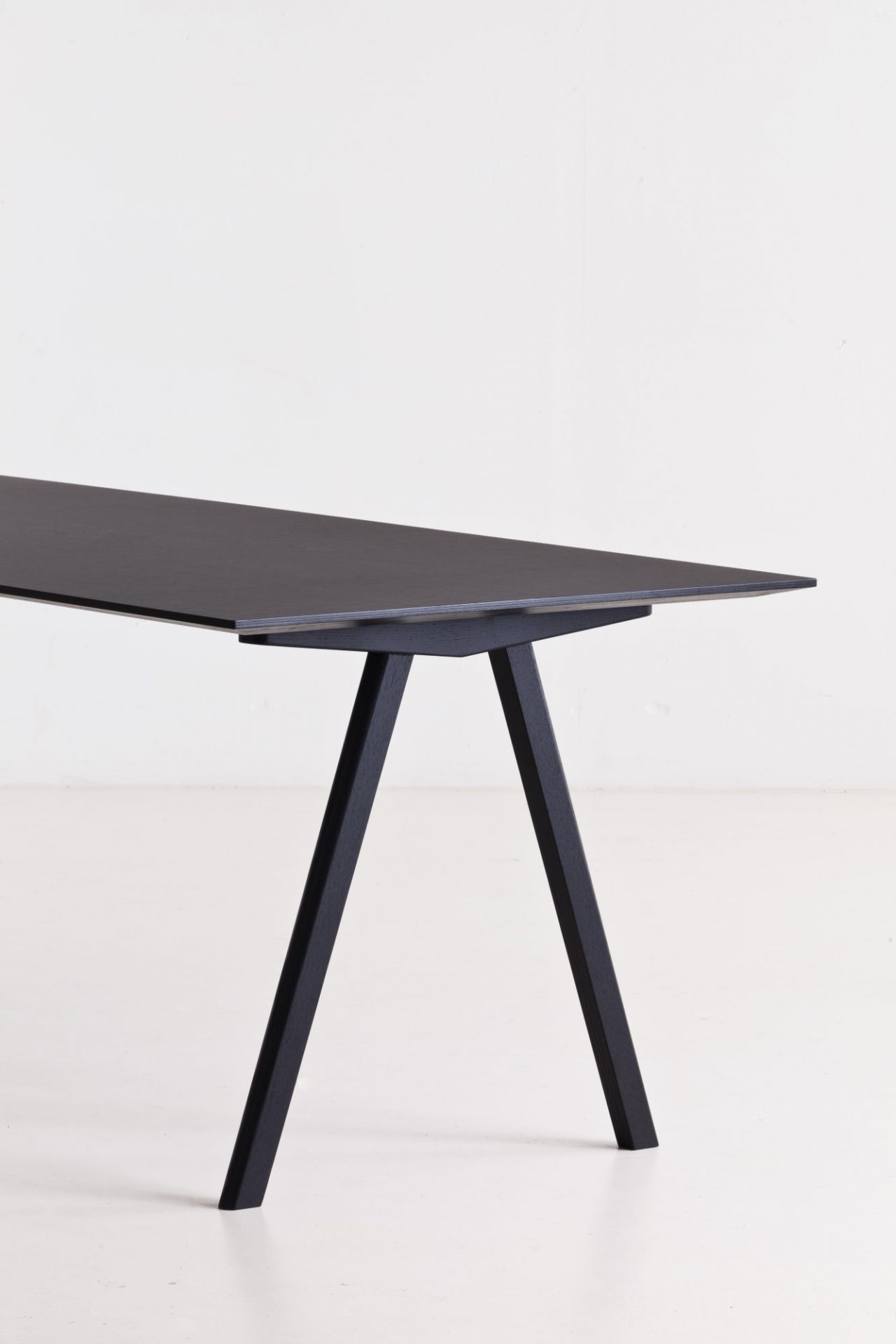 Detailaufnahme des Copenhague Table CPH 10 Tisches von Hay in Schwarz, minimalistisches Design mit schrägen Tischbeinen.