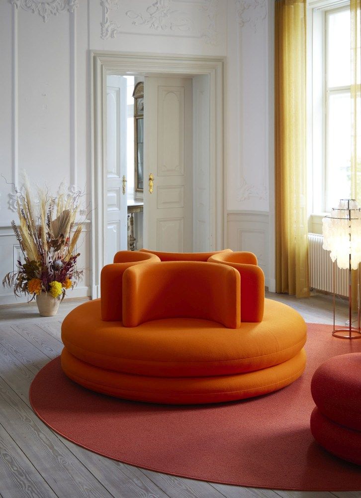 Orangefarbenes Verpan Easy Sofa im Wohnzimmer, modernes modulares Sitzmöbel mit runder Form und Rückenlehne.