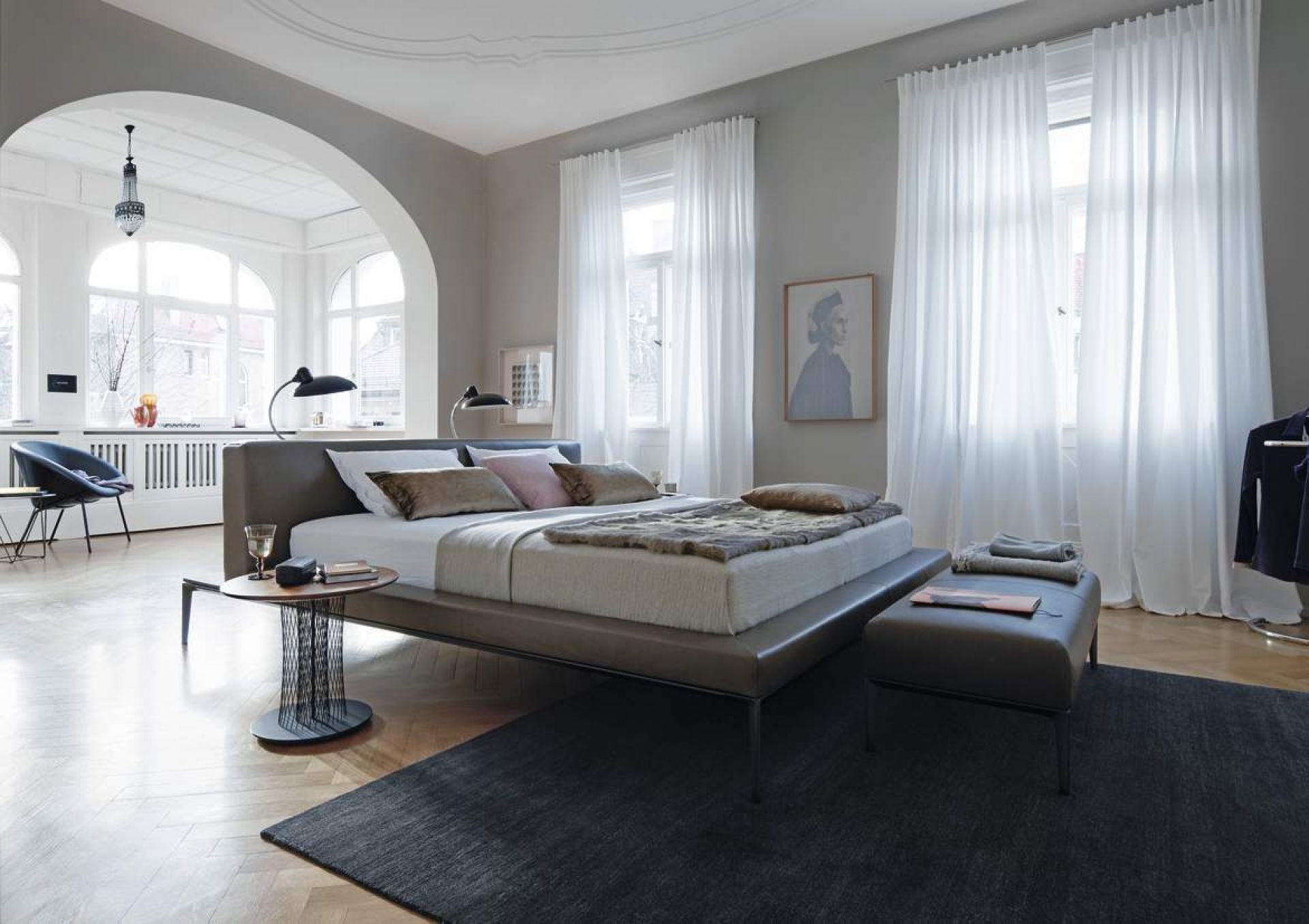 Helles Schlafzimmer mit modernem Lederbett, Beistelltisch und Teppich. Walter Knoll Bett im minimalistischen Design.