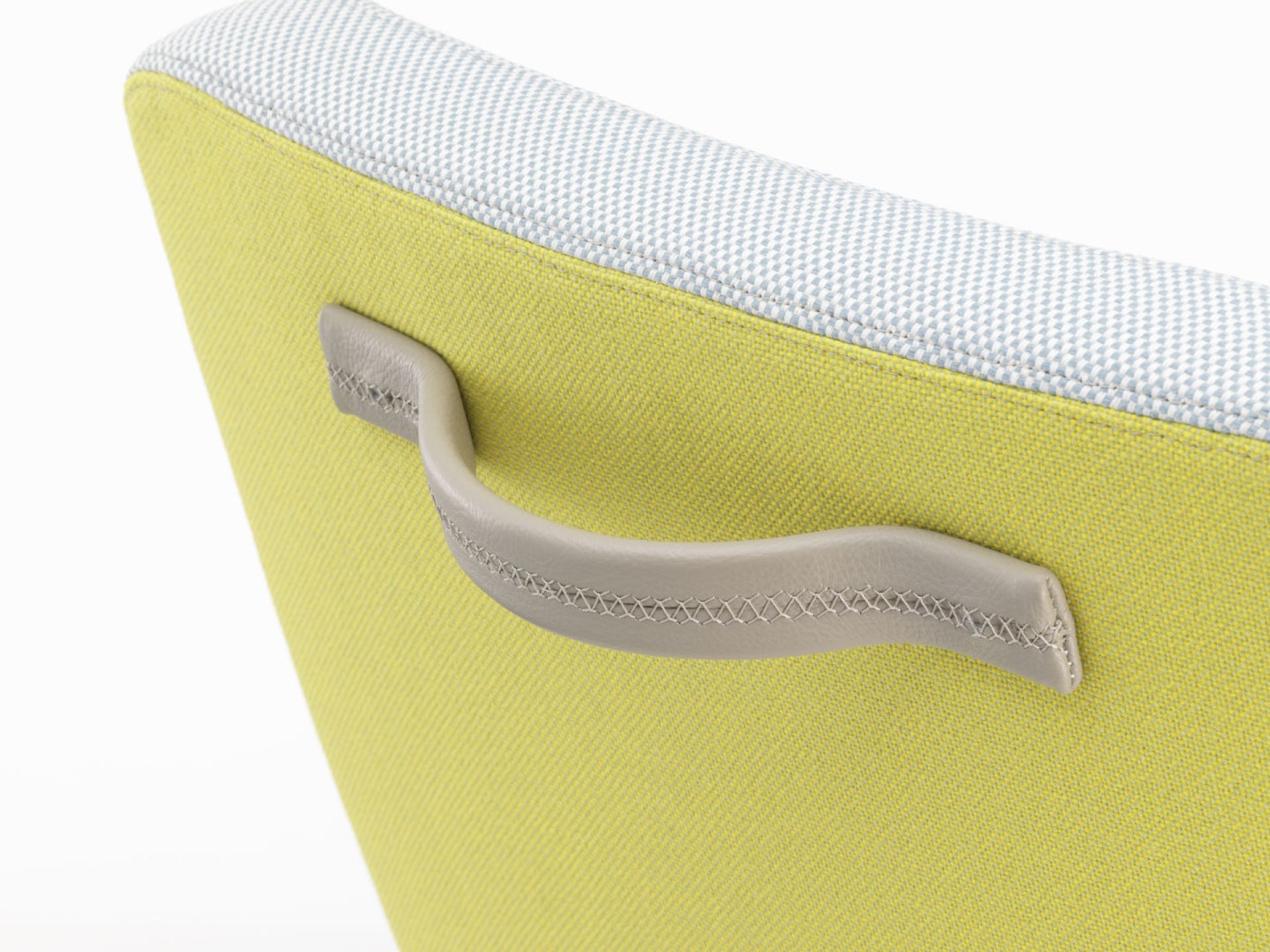 Detailaufnahme des East River Chair Sessels von Vitra: Gelber Stoffbezug mit grauem Ledergriff.