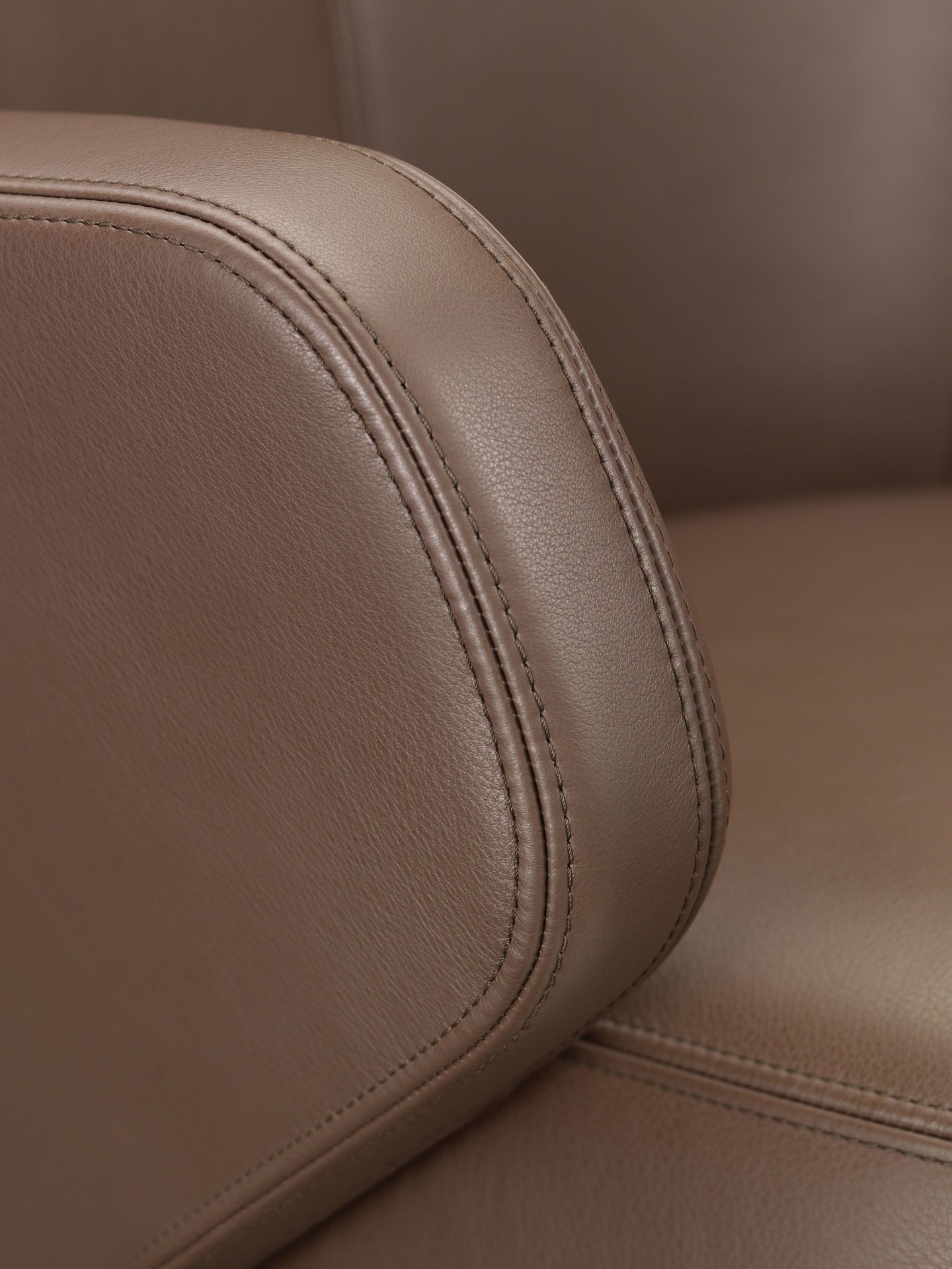 Detailaufnahme: Brauner Vitra Grand Executive Konferenzstuhl mit feinen Ledernähten für hochwertige Büromöbel.