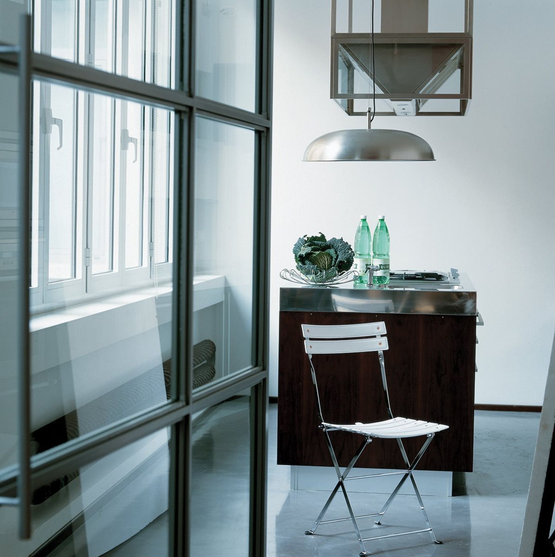 Celestina Klappstuhl von Zanotta: Weißer Design-Klappstuhl mit Chromgestell in moderner Küche.