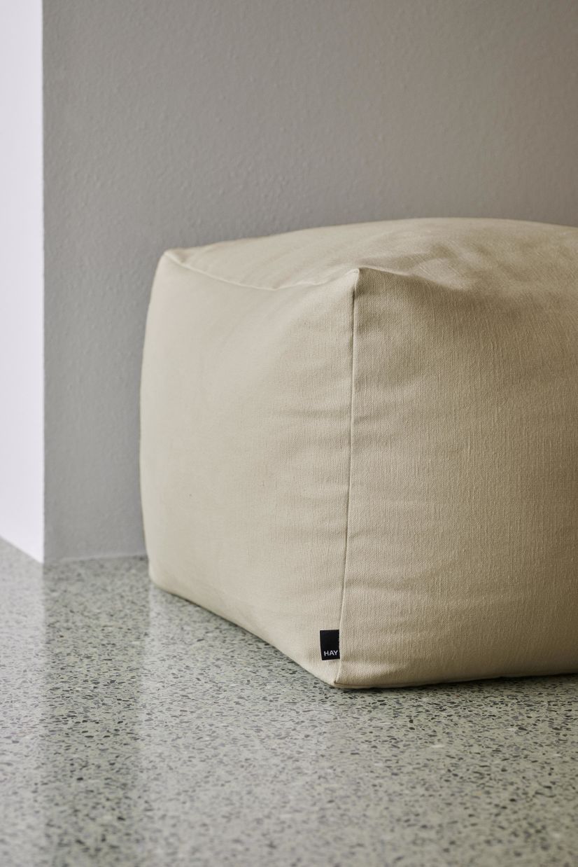 Nahaufnahme des hellgrauen Hay Planar Pouf Hockers, ein moderner Sitzhocker für Wohnzimmer.