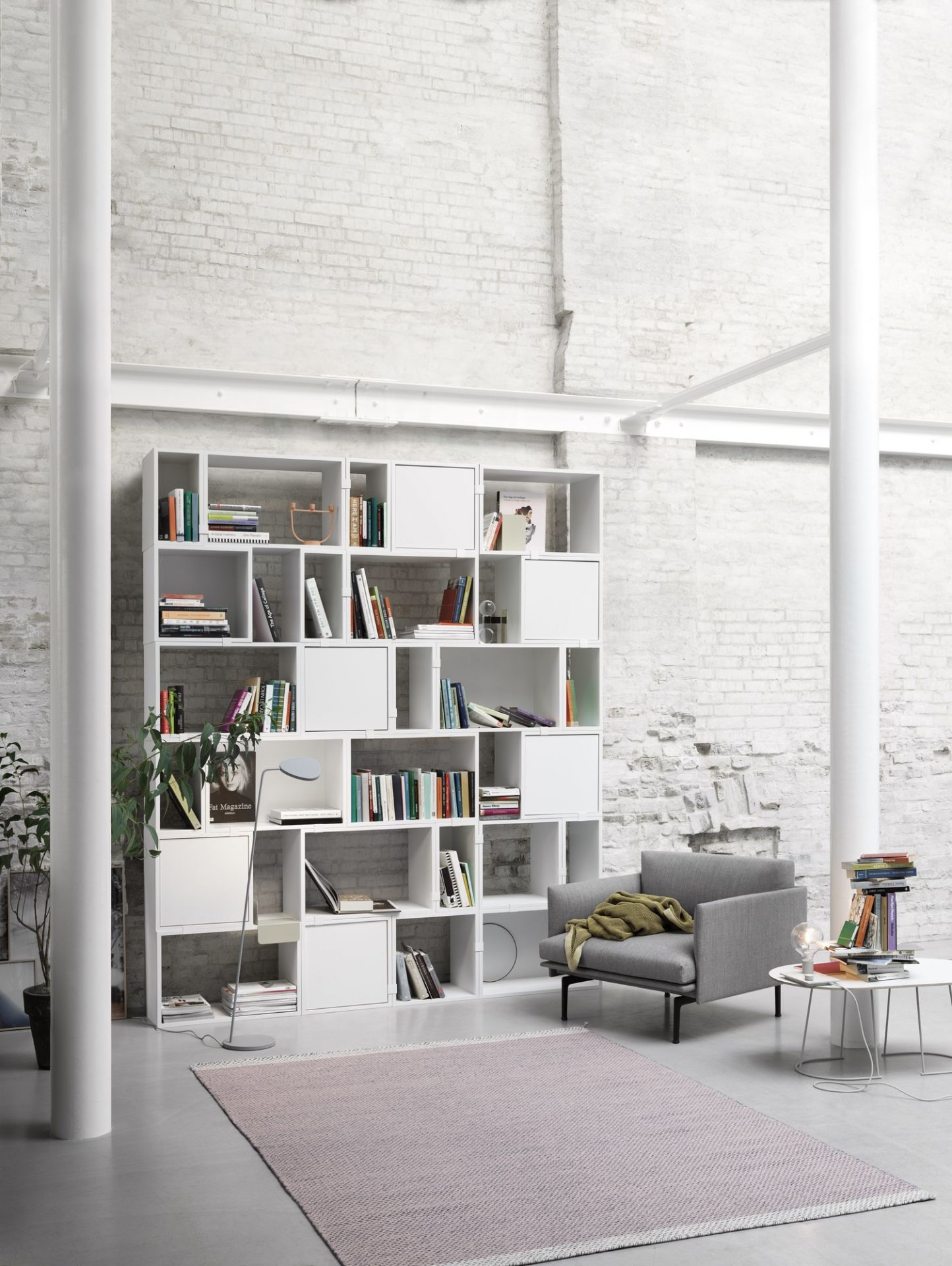 Dunkelgrüne Muuto Leaf Stehleuchte im Wohnzimmer mit Bücherregal und Sessel. Moderne Bodenleuchte.