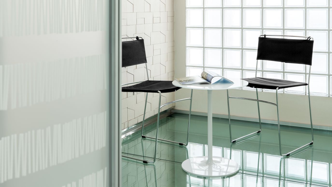 Poppy Beistelltisch von Rexite, runder, weißer Tisch mit zwei schwarzen Stühlen in modernem Interieur.