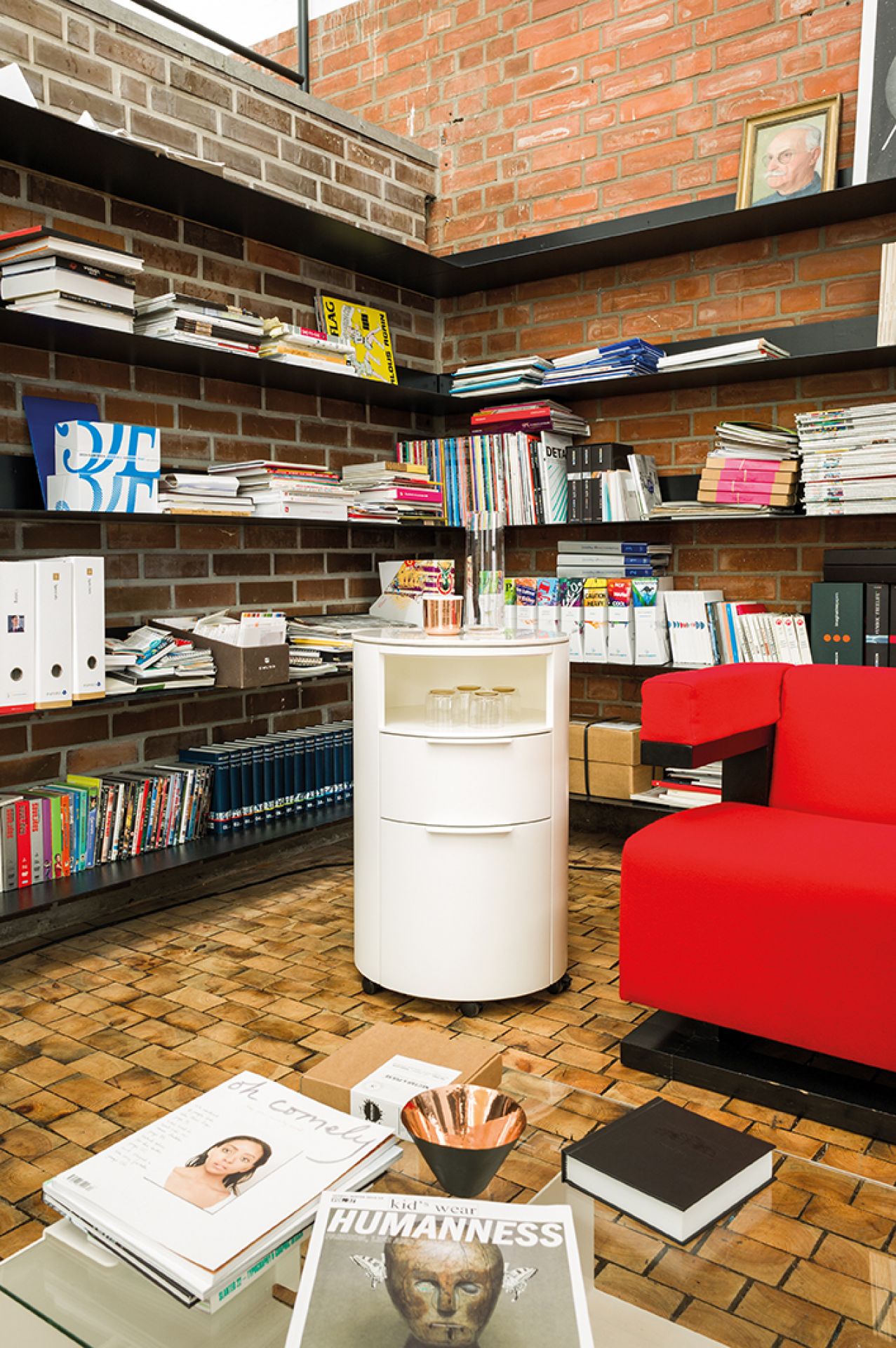 Weiße Conga Rundkommode von Schönbuch mit drei Schubladen im modernen Wohnzimmer mit Bücherregalen.