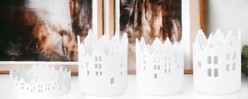 Zuhause Lichthaus Sortiment: Vier weiße Räder Stadtlichter Teelichthalter mit Hausmuster für stimmungsvolle Beleuchtung.