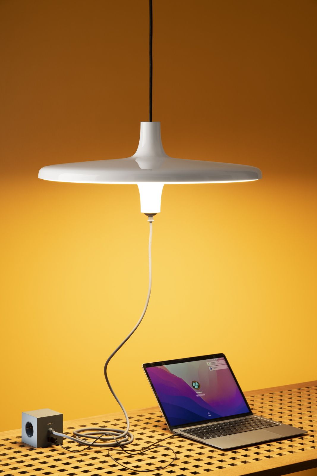 Avro Hängeleuchte von Martinelli Luce: Moderne Pendelleuchte in Weiß über einem Laptop.